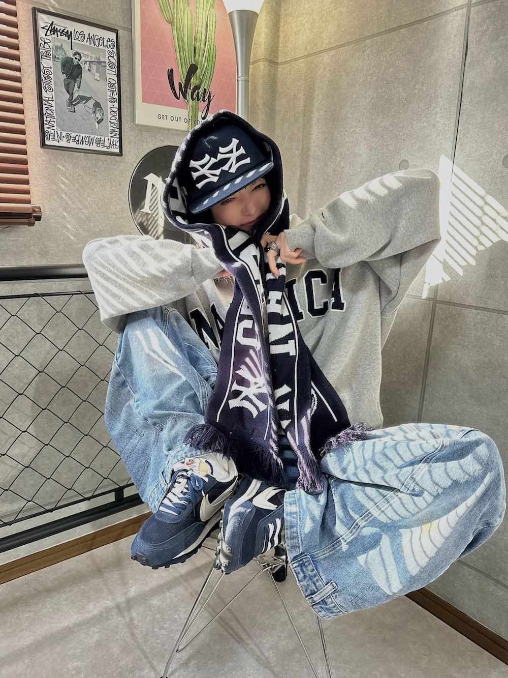 グレー系のスウェット、ブルー系のデニムパンツ、ブルー系のマフラーを着用したレディースの冬コーディネートの2枚目の写真