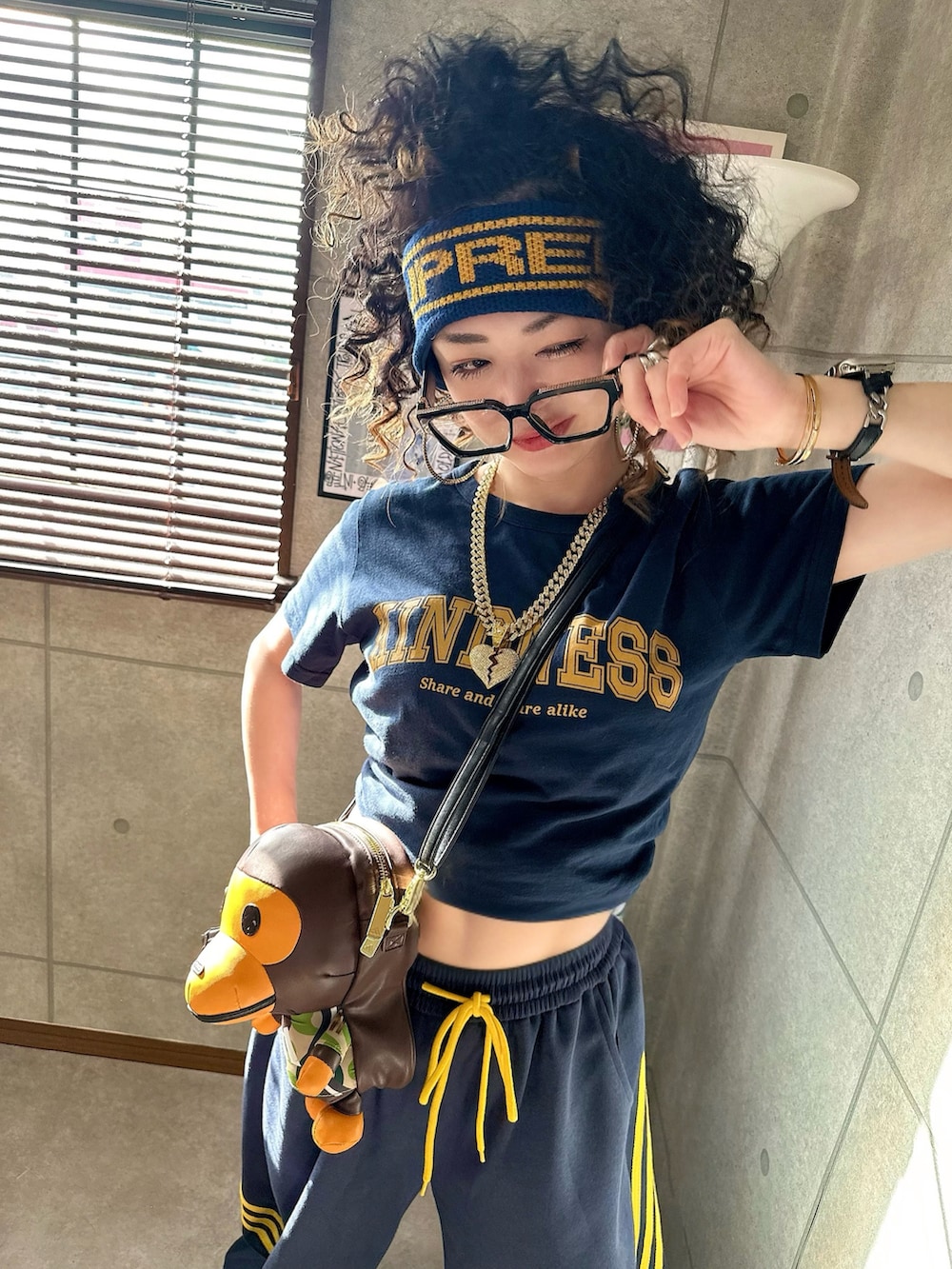 ブラウン系のショルダーバッグ、ブルー系のパンツ、イエロー系のスニーカーを着用したレディースの秋コーディネートの3枚目の写真