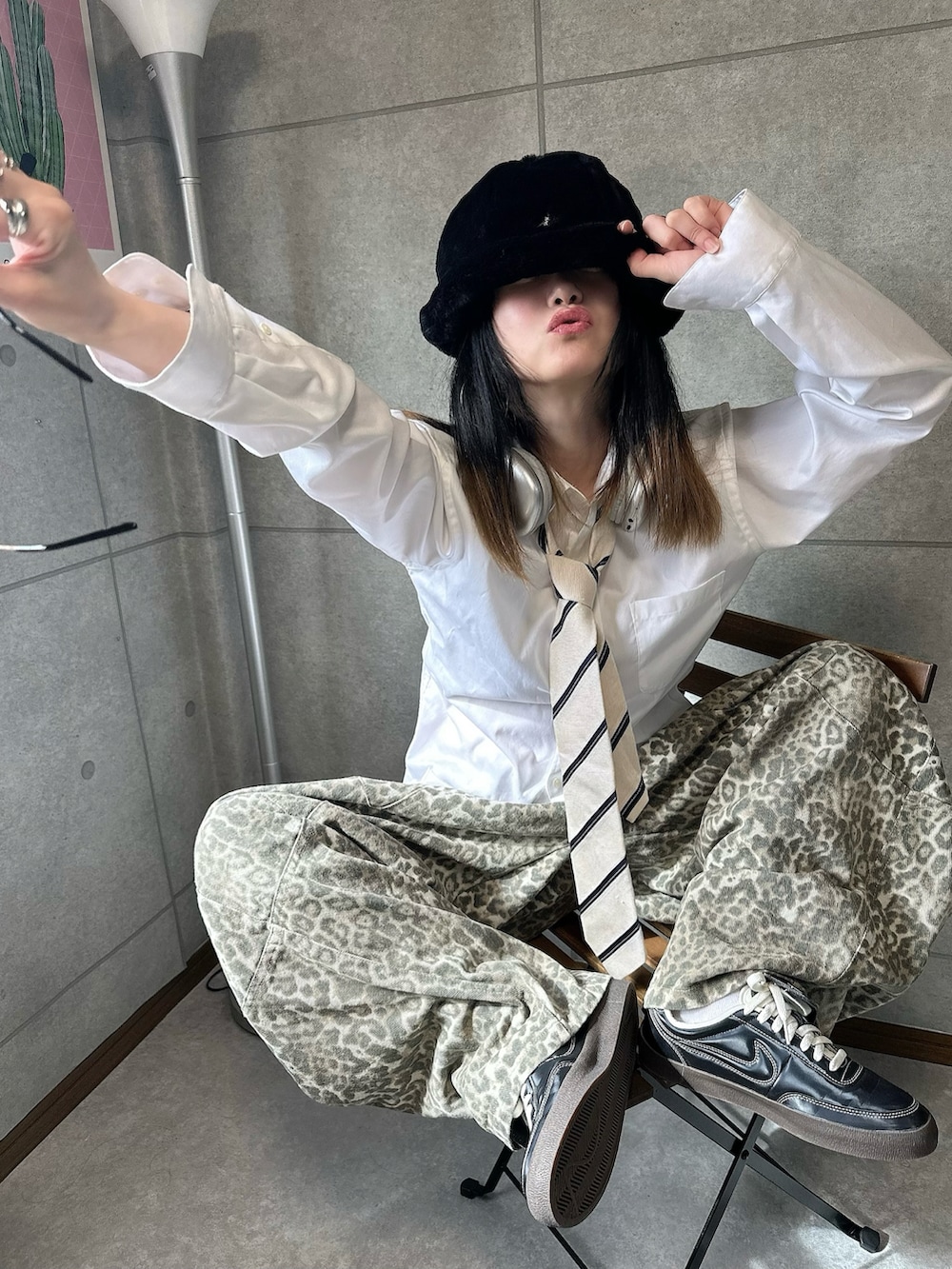 ベージュ系のデニムパンツ、ブラック系のスニーカー、ブラック系のハットを着用したレディースの秋コーディネートの2枚目の写真