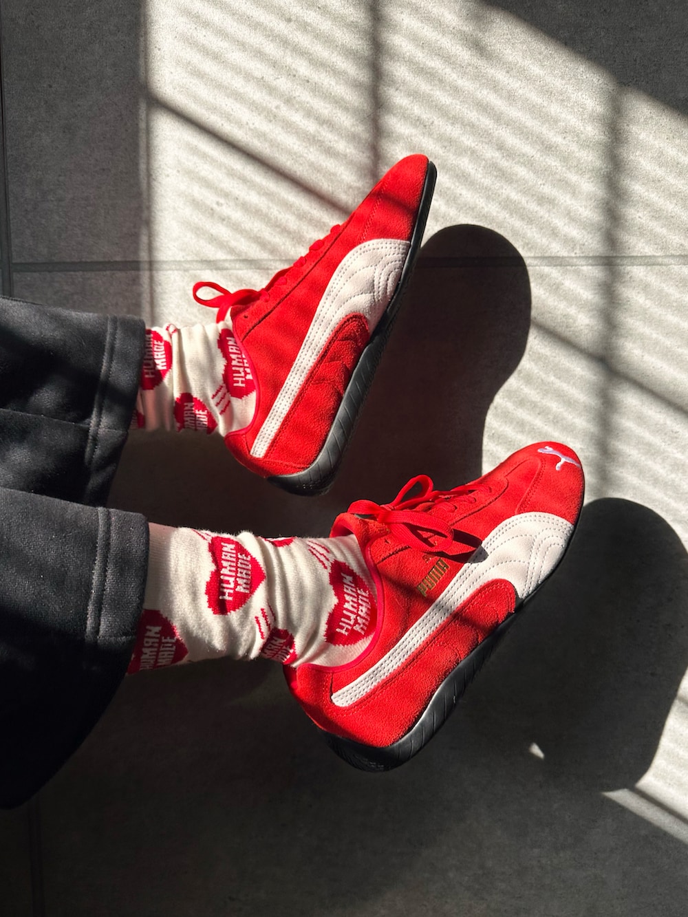 レッド系のスニーカー、ホワイト系のスウェット、ブラック系のスウェットパンツを着用したレディースの秋コーディネートの3枚目の写真