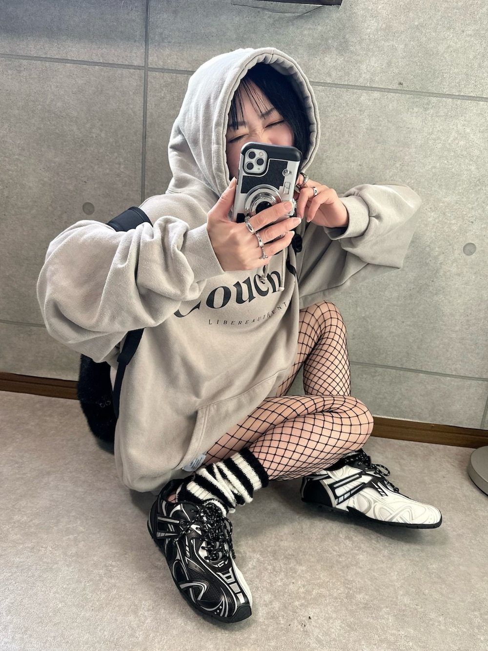 ベージュ系のパーカー、シルバー系のスニーカーを着用したレディースの冬コーディネートの3枚目の写真