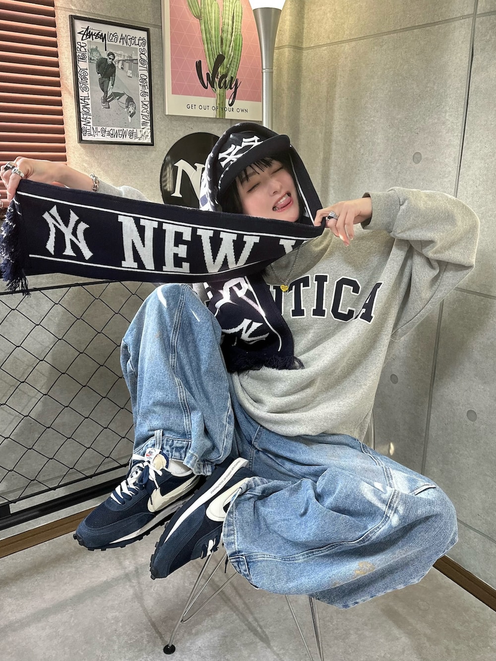 グレー系のスウェット、ブルー系のデニムパンツ、ブルー系のマフラーを着用したレディースの冬コーディネートの4枚目の写真