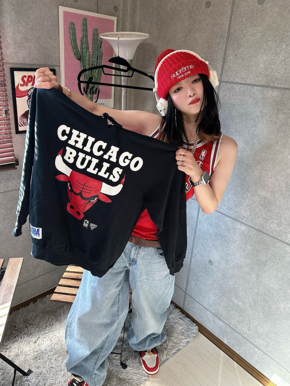 レッド系のタンクトップ、レッド系のスニーカー、ブルー系のデニムパンツを着用したレディースの春コーディネートの4枚目の写真