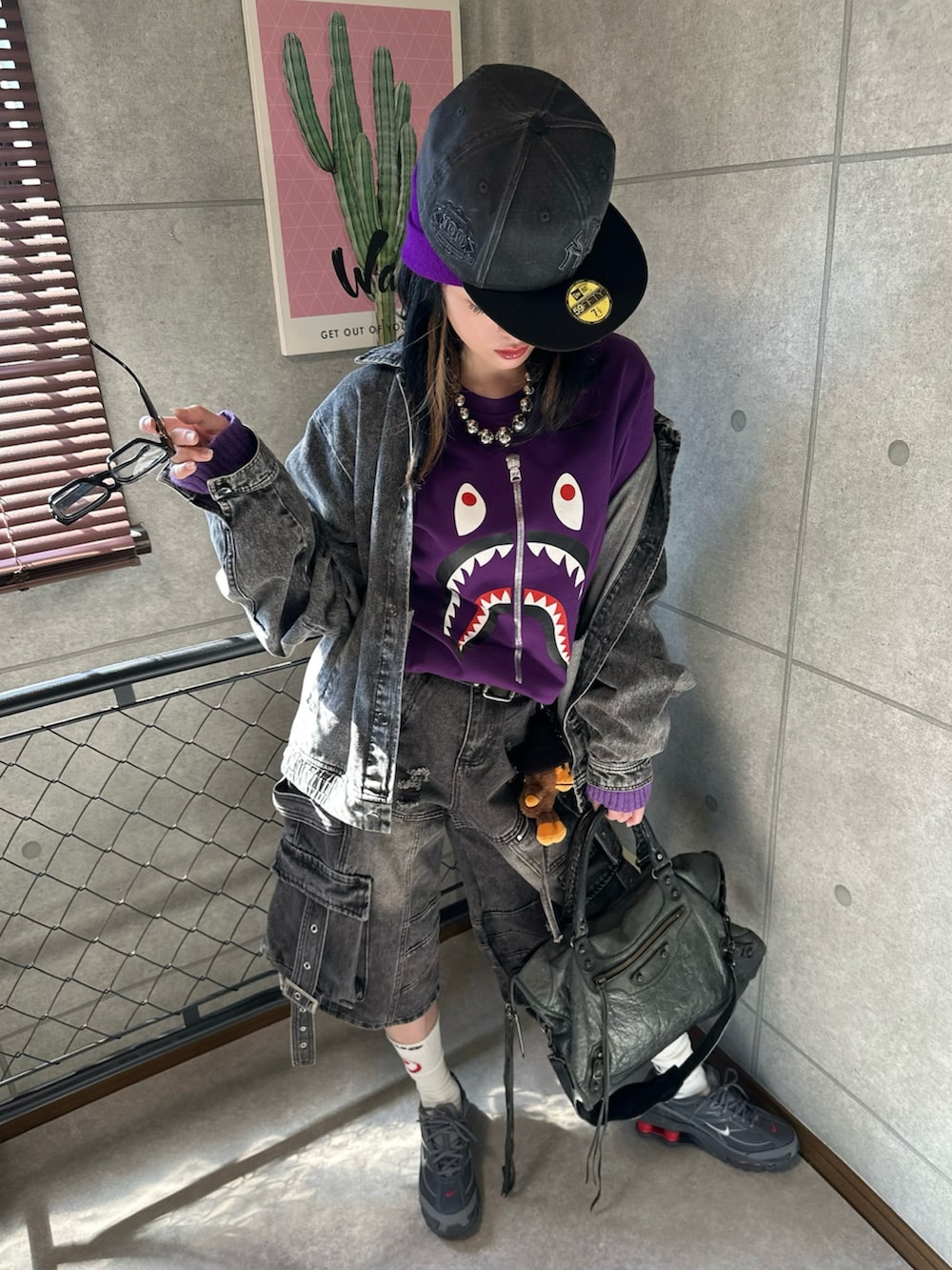 ブラック系のデニムジャケット、ブラック系のデニムパンツ、パープル系のTシャツ/カットソーを着用したレディースの秋コーディネートの2枚目の写真