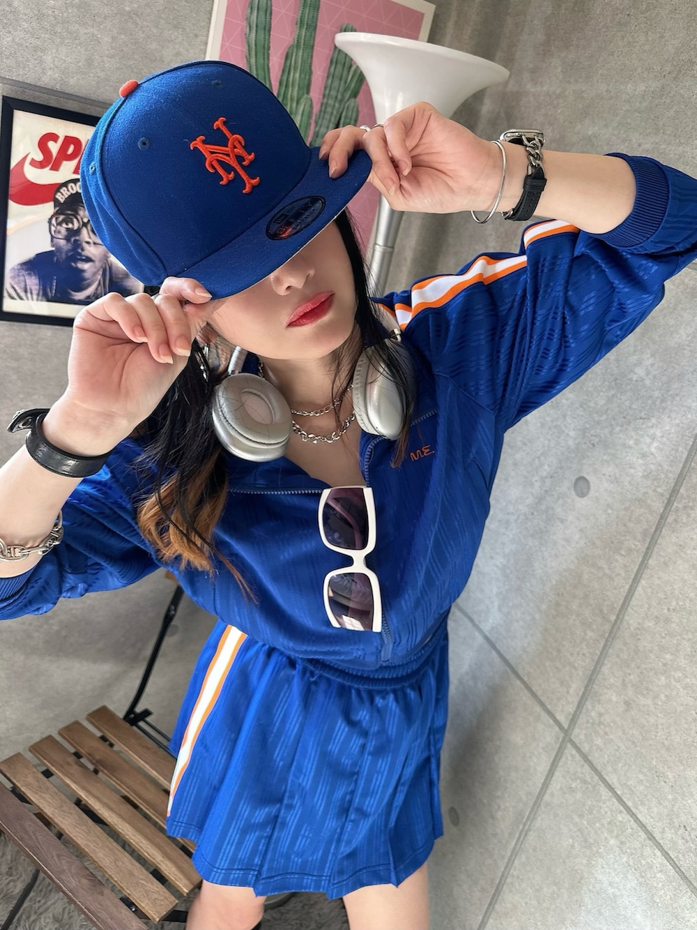 ブルー系のジャージ、グレー系のスニーカー、ブルー系のキャップを着用したレディースの夏コーディネートの2枚目の写真