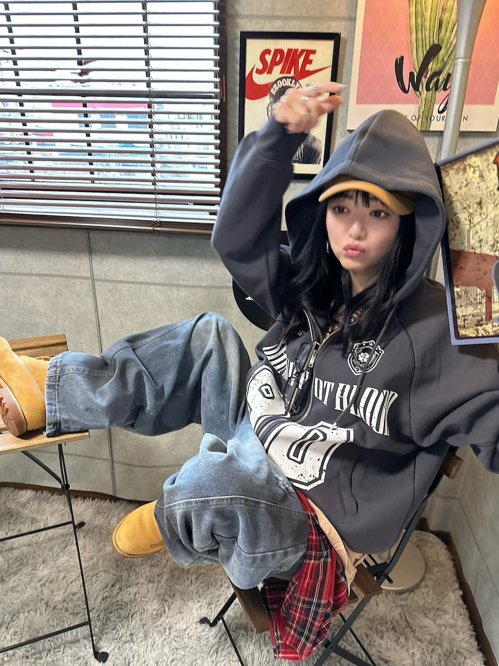 グレー系のパーカー、ブルー系のデニムパンツ、ベージュ系のブーツを着用したレディースの冬コーディネートの3枚目の写真