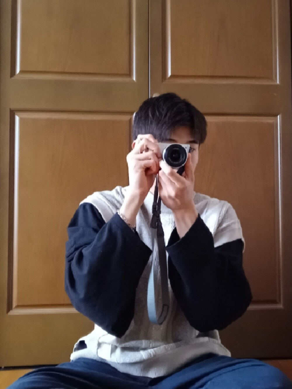 ブラック系のTシャツ/カットソー、ホワイト系のベスト、ブルー系のスラックスを着用したメンズの冬コーディネートの2枚目の写真