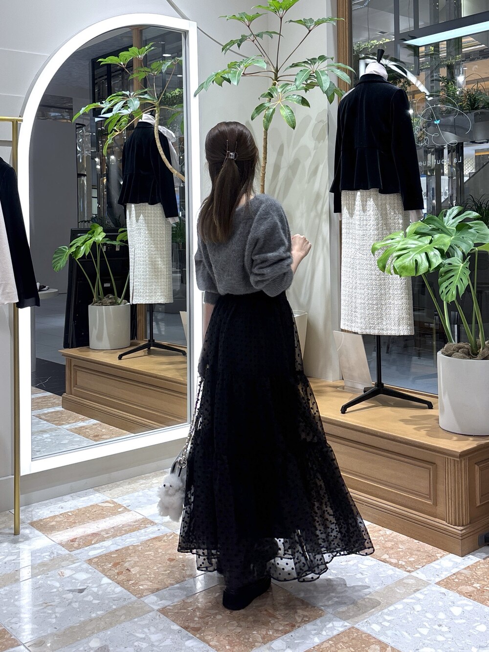 グレー系のニット/セーター、ブラック系のスカートを着用したレディースの秋コーディネートの3枚目の写真