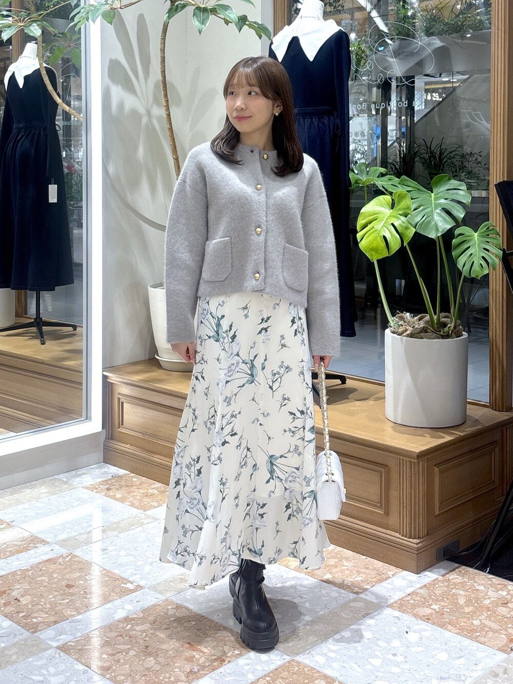 グレー系のノーカラージャケット、ホワイト系のスカートを着用したレディースの冬コーディネートの3枚目の写真