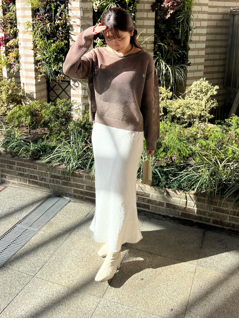 グレー系のスカート、ブラック系のニット/セーター、ブラウン系のニット/セーターを着用したレディースの冬コーディネートの3枚目の写真