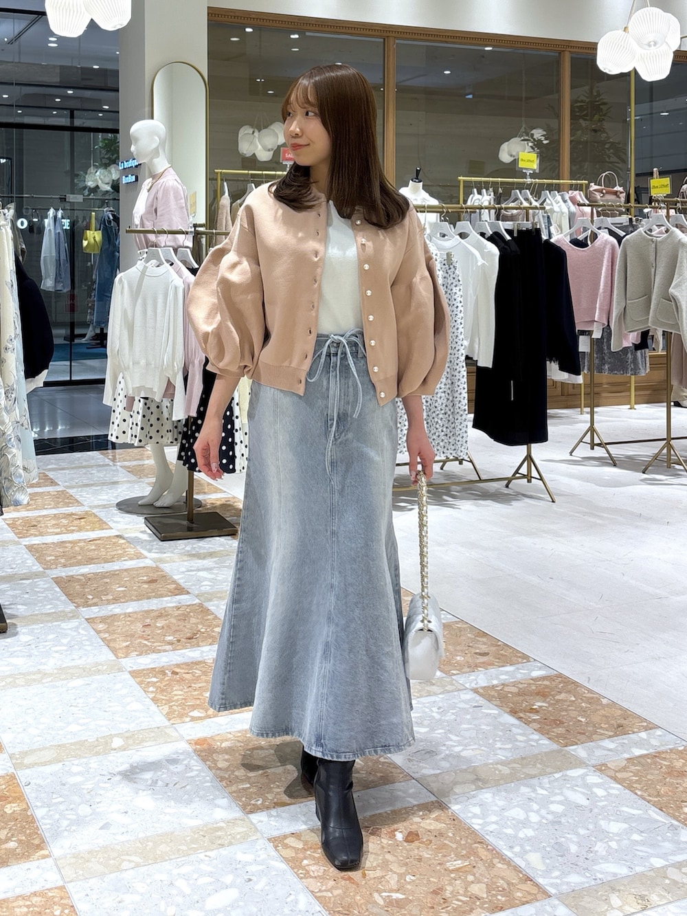 ピンク系のカーディガン/ボレロ、ブルー系のデニムスカートを着用したレディースの冬コーディネートの2枚目の写真