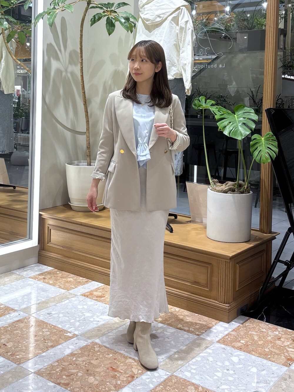 ベージュ系のテーラードジャケット、グレー系のスカート、ブルー系のシャツ/ブラウスを着用したレディースの冬コーディネートの3枚目の写真