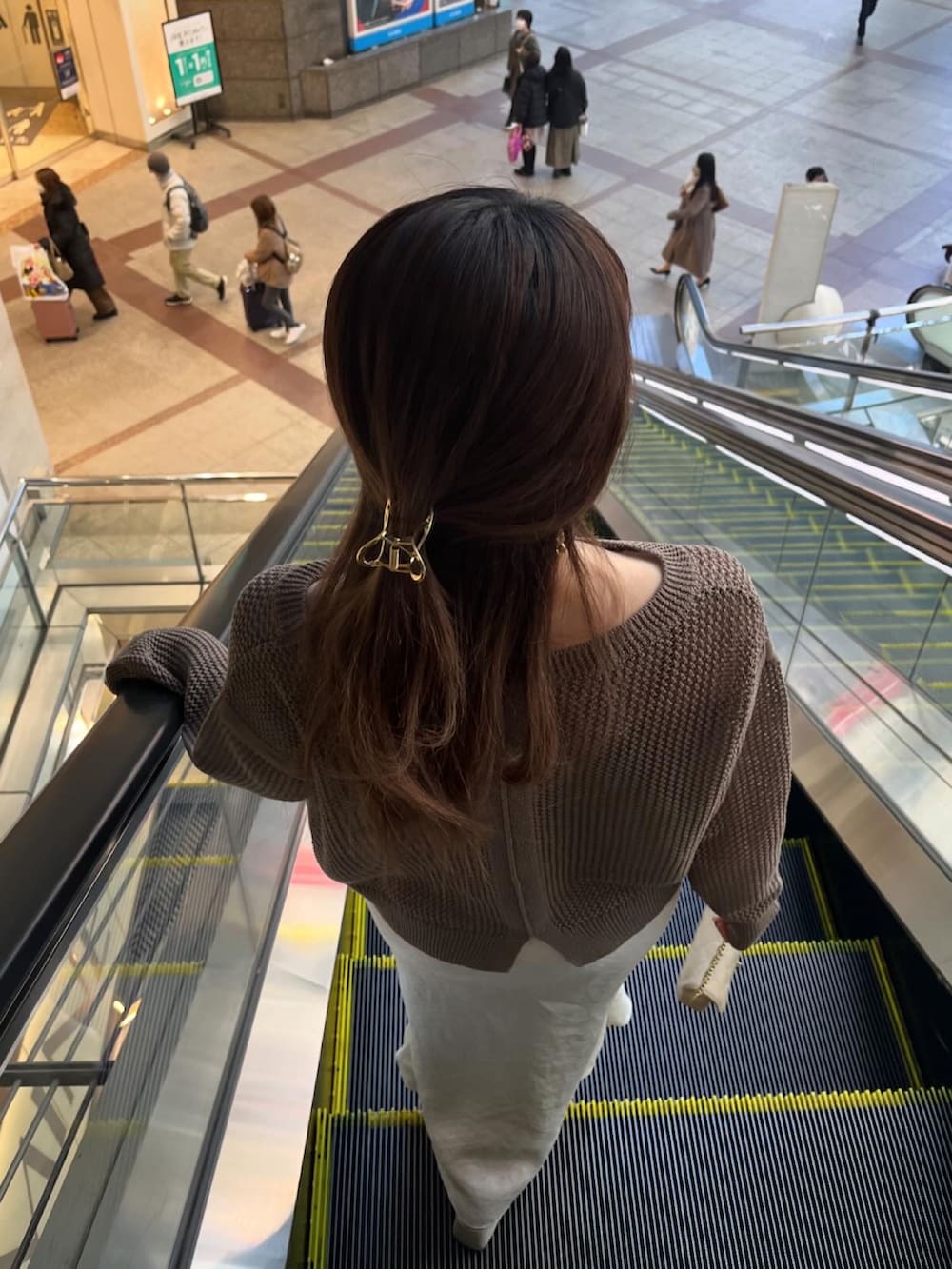 グレー系のスカート、ブラック系のニット/セーター、ブラウン系のニット/セーターを着用したレディースの冬コーディネートの2枚目の写真