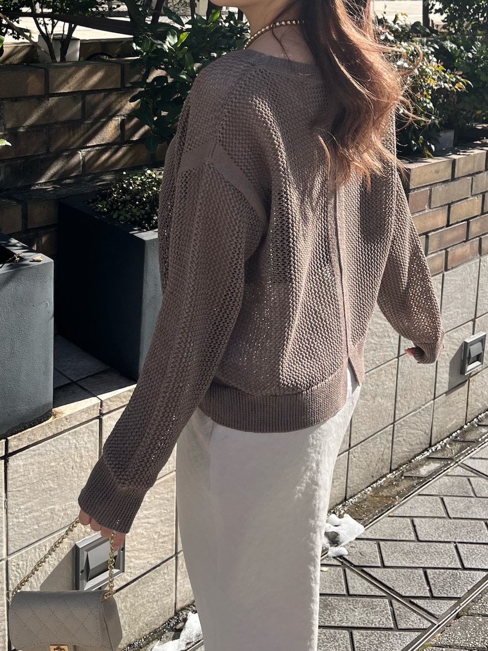 グレー系のスカート、ブラック系のニット/セーター、ブラウン系のニット/セーターを着用したレディースの冬コーディネートの4枚目の写真