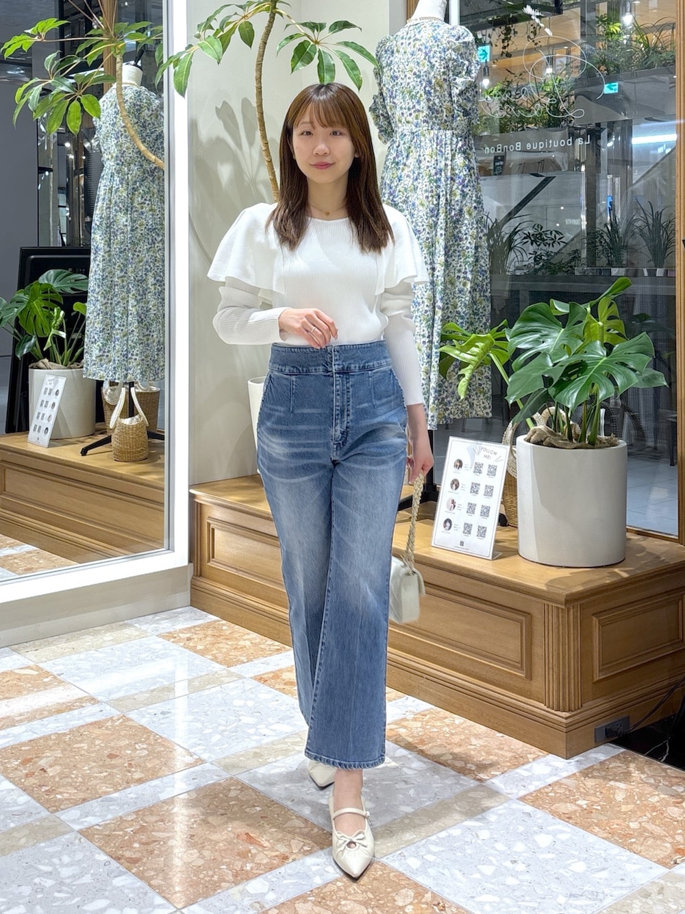 ブルー系のデニムパンツ、ホワイト系のニット/セーターを着用したレディースの春コーディネートの2枚目の写真