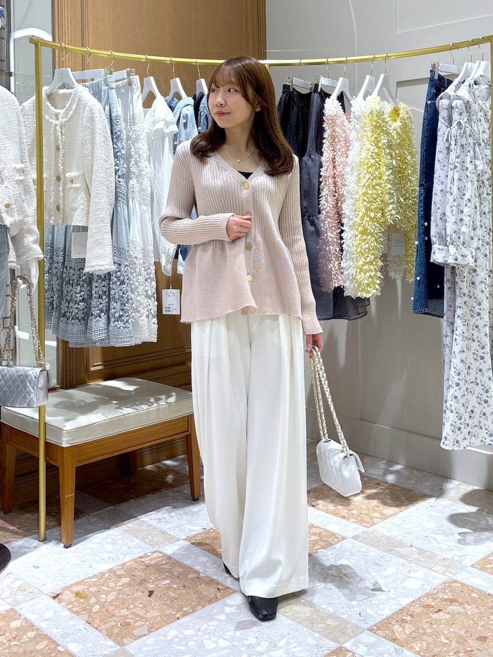ピンク系のカーディガン/ボレロ、ホワイト系のスラックスを着用したレディースの冬コーディネートの2枚目の写真