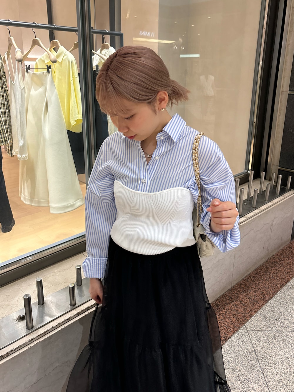 ブラック系のスカート、ホワイト系のニット/セーター、ホワイト系のショルダーバッグを着用したレディースの夏コーディネートの4枚目の写真