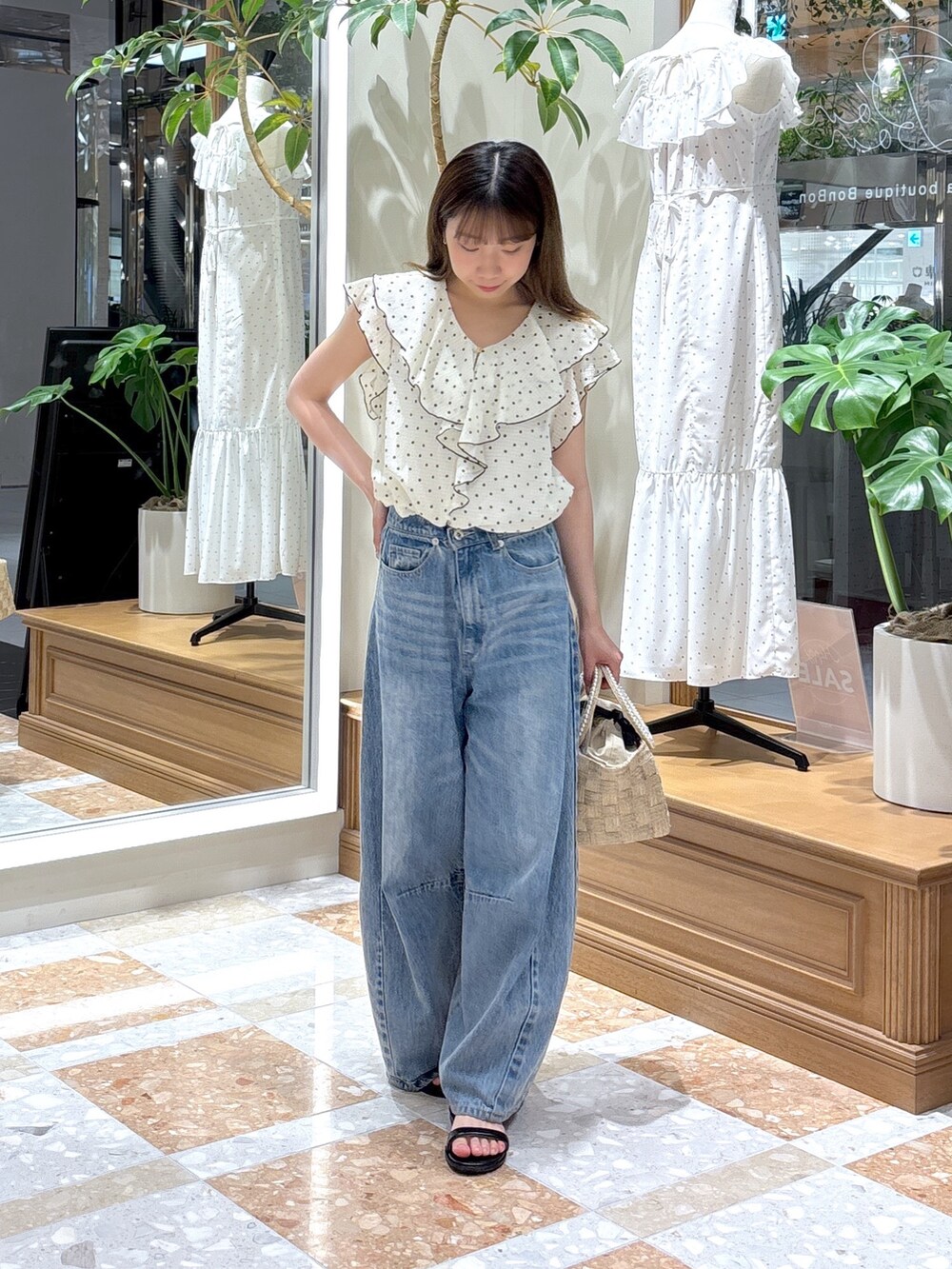 ホワイト系のシャツ/ブラウス、ベージュ系のトートバッグ、ブルー系のデニムパンツを着用したレディースの夏コーディネートの3枚目の写真