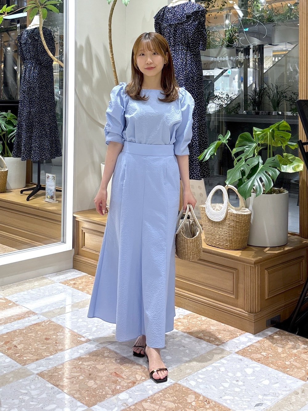 ブルー系のシャツ/ブラウス、ブルー系のスカート、ベージュ系のかごバッグを着用したレディースの春コーディネートの2枚目の写真