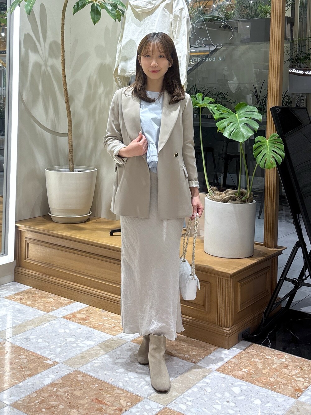 ベージュ系のテーラードジャケット、グレー系のスカート、ブルー系のシャツ/ブラウスを着用したレディースの冬コーディネートの2枚目の写真