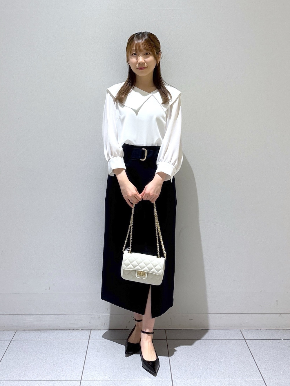 ブルー系のスカート、ホワイト系のシャツ/ブラウス、ブラック系のサンダルを着用したレディースの春コーディネートの3枚目の写真
