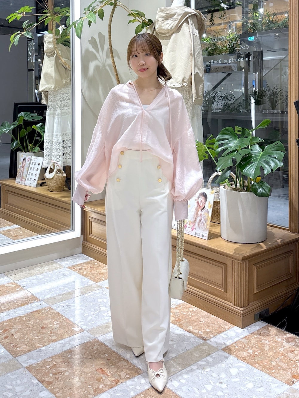 イエロー系のシャツ/ブラウス、ホワイト系のスラックスを着用したレディースの春コーディネートの2枚目の写真