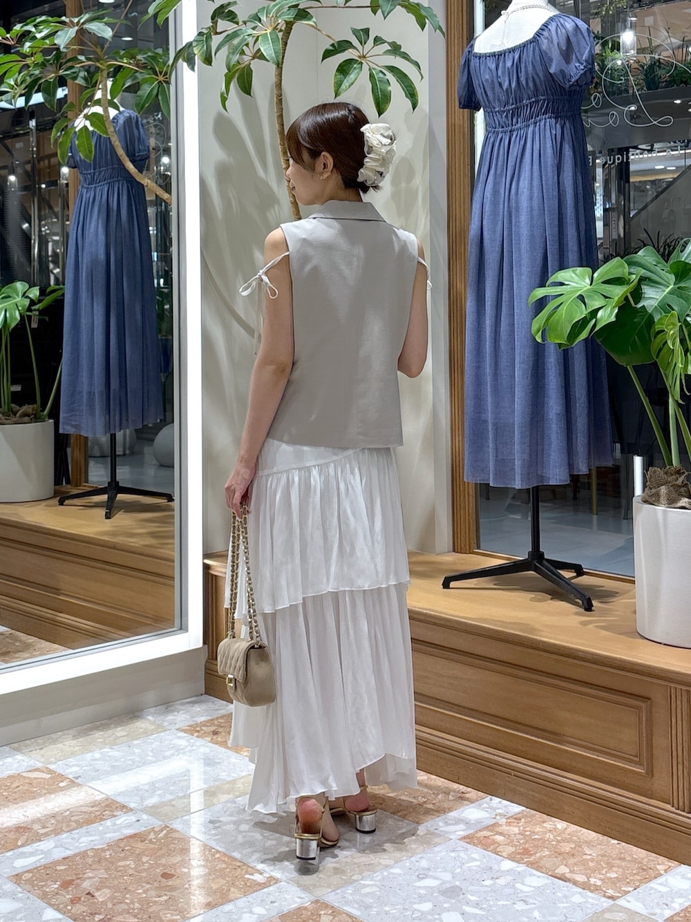 ベージュ系のベスト、ホワイト系のスカートを着用したレディースの秋コーディネートの3枚目の写真