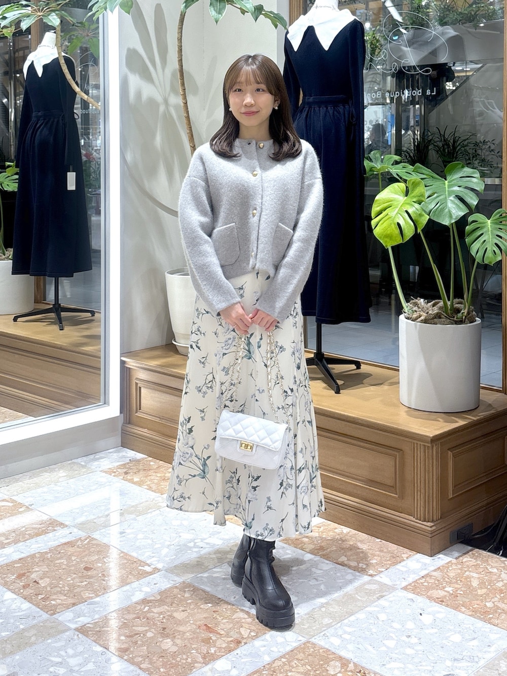 グレー系のノーカラージャケット、ホワイト系のスカートを着用したレディースの冬コーディネートの2枚目の写真