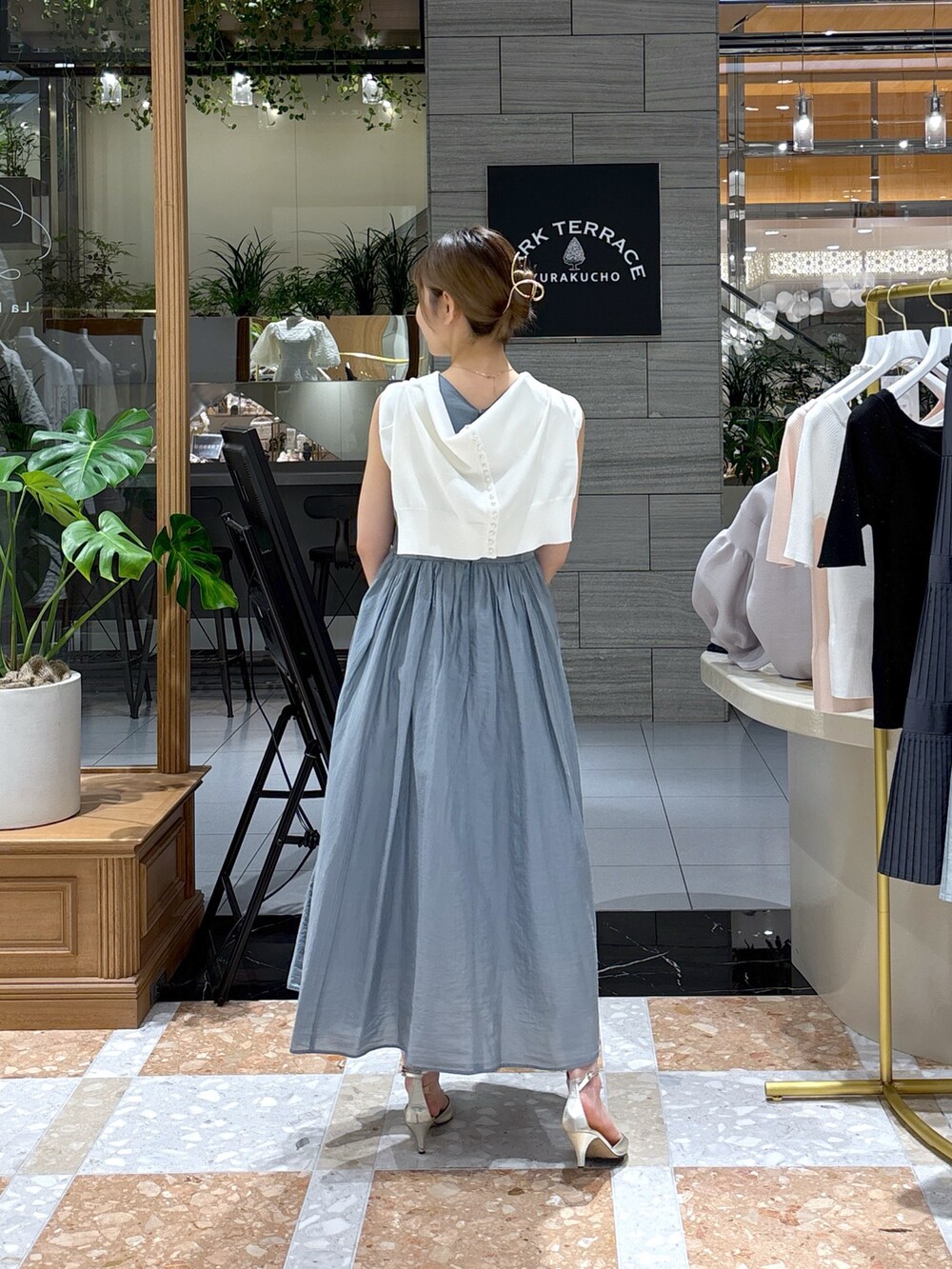 ブルー系のワンピース、ホワイト系のカーディガン/ボレロ、ベージュ系のかごバッグを着用したレディースの春コーディネートの3枚目の写真