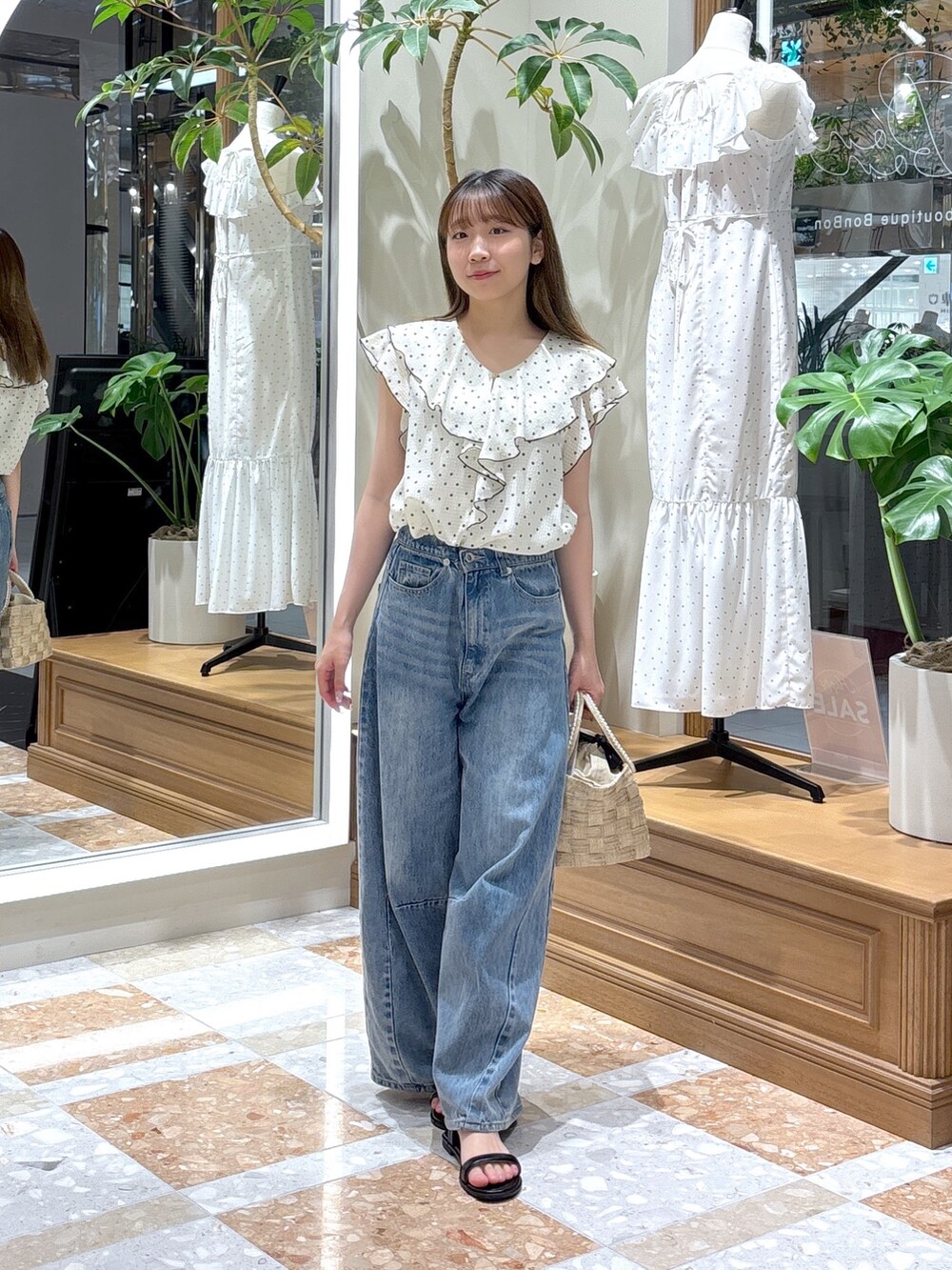 ホワイト系のシャツ/ブラウス、ベージュ系のトートバッグ、ブルー系のデニムパンツを着用したレディースの夏コーディネートの2枚目の写真