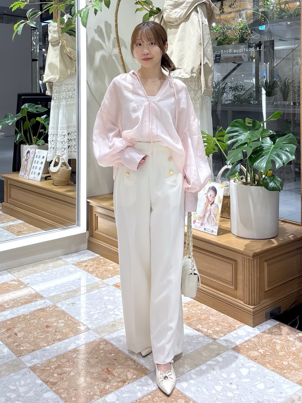 イエロー系のシャツ/ブラウス、ホワイト系のスラックスを着用したレディースの春コーディネートの4枚目の写真