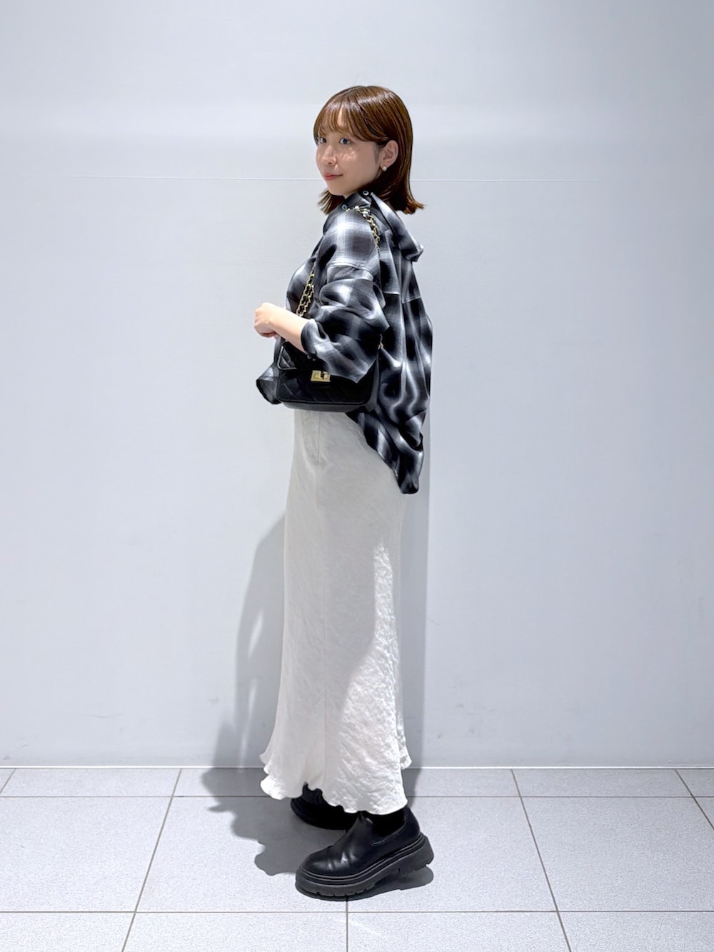 ブラック系のシャツ/ブラウス、グレー系のスカートを着用したレディースの秋コーディネートの2枚目の写真