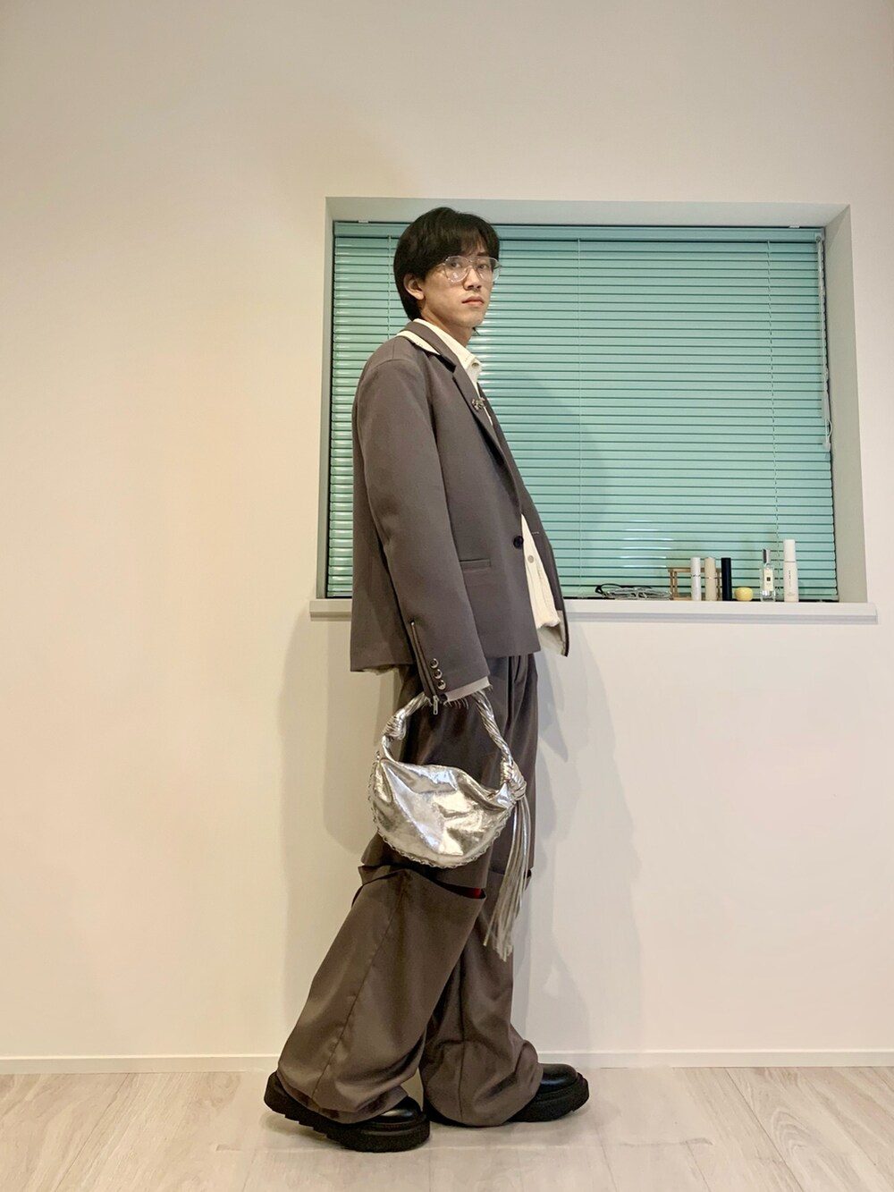 グレー系のテーラードジャケット、グレー系のスラックス、ブラック系のブーツを着用したメンズの春コーディネートの4枚目の写真