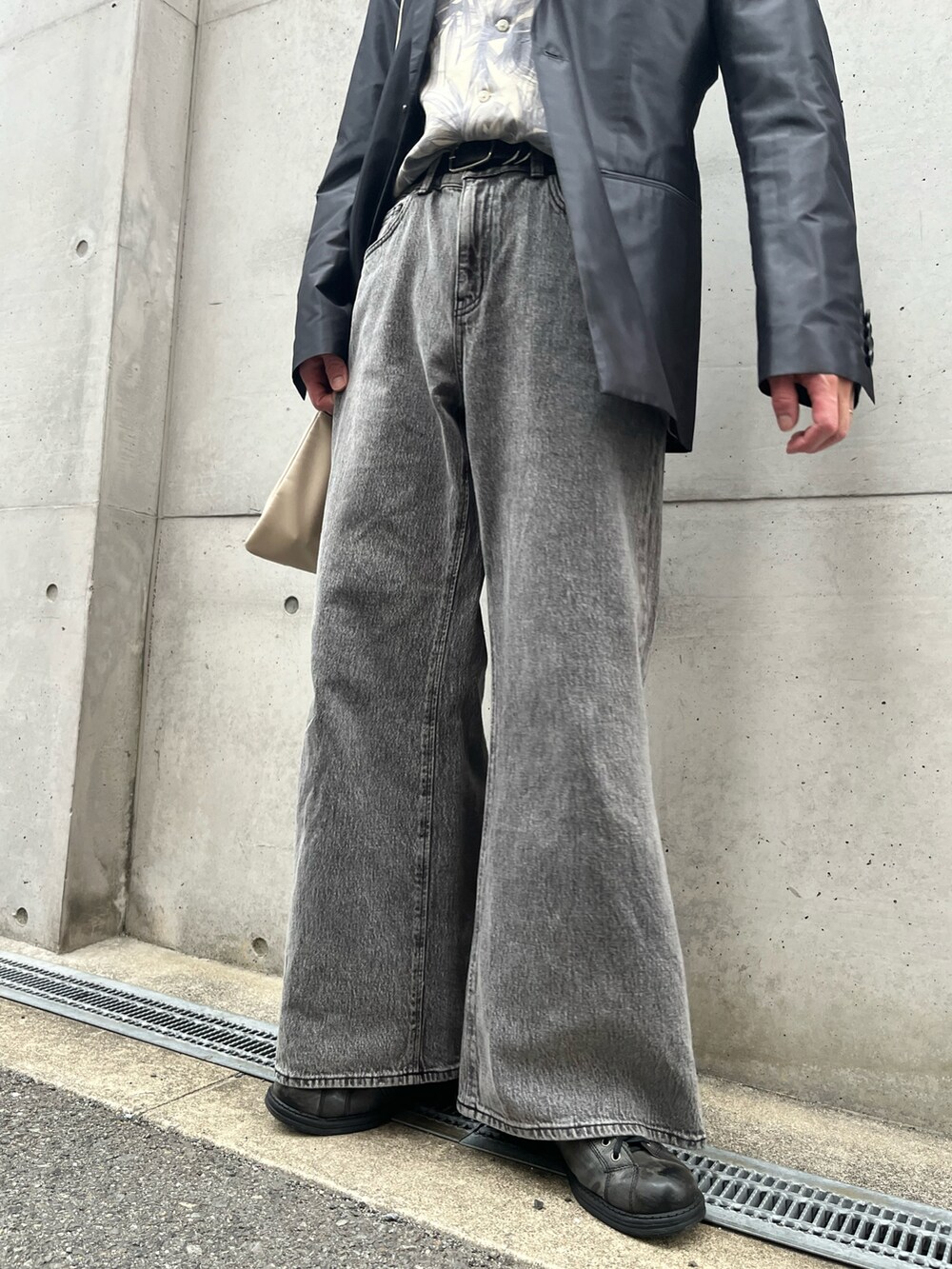 グレー系のデニムパンツ、ベージュ系のショルダーバッグを着用したメンズの春コーディネートの3枚目の写真