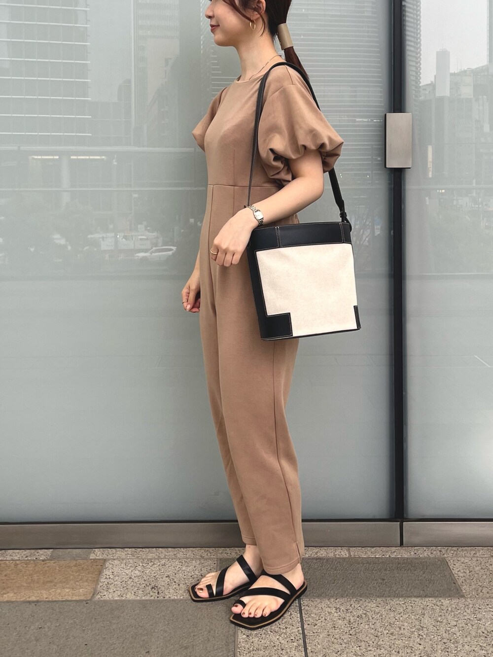 ブラック系のショルダーバッグ、ブラック系のサンダル、ブラウン系のオールインワン・サロペットを着用したレディースの春コーディネートの2枚目の写真