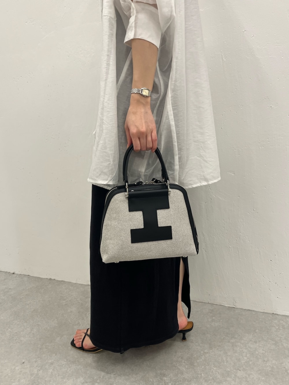 ホワイト系のシャツ/ブラウス、ブラック系のトートバッグ、ブラック系のサンダルを着用したレディースの春コーディネートの2枚目の写真