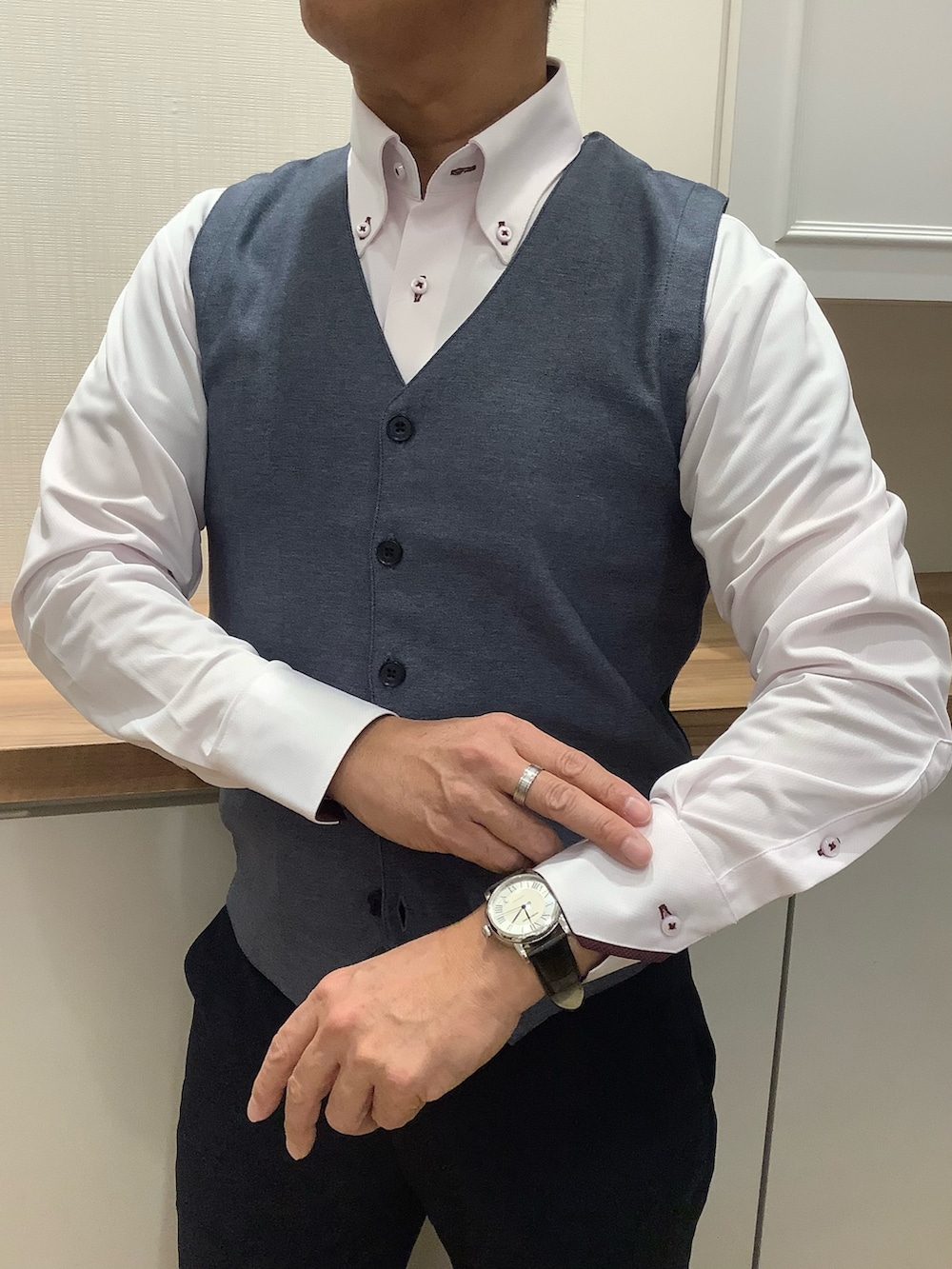 ブルー系のベスト、グレー系のネクタイ、ピンク系のビジネスシャツを着用したメンズの冬コーディネートの2枚目の写真