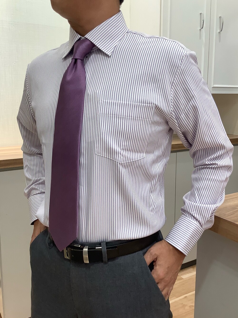 ブルー系のビジネスシャツ、パープル系のネクタイ、ブラック系のスーツジャケットを着用したメンズの秋コーディネートの2枚目の写真