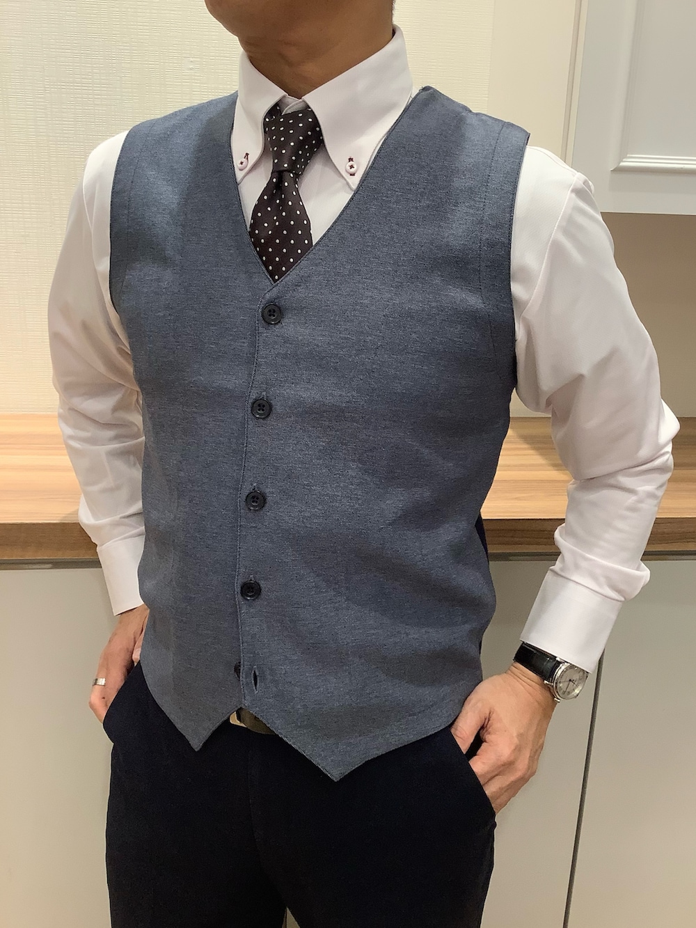 ブルー系のベスト、グレー系のネクタイ、ピンク系のビジネスシャツを着用したメンズの冬コーディネートの3枚目の写真