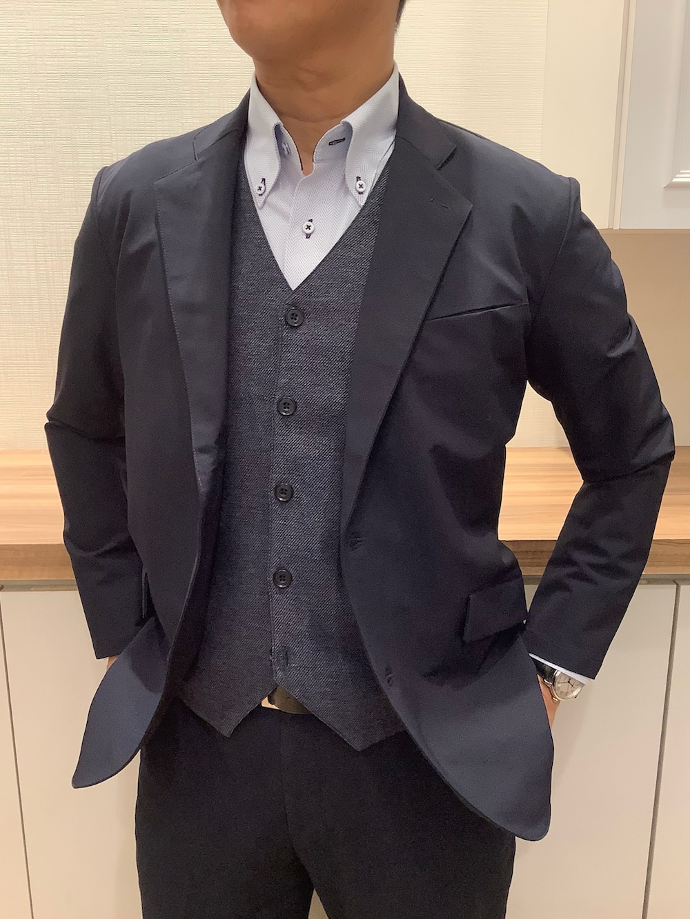 ブルー系のベスト、ブルー系のビジネスシャツ、ブルー系のスーツジャケットを着用したメンズの冬コーディネートの2枚目の写真