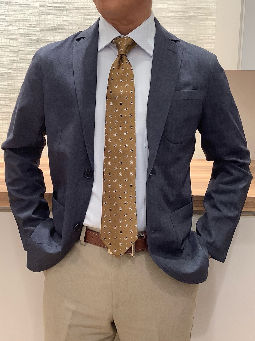 ブルー系のビジネスシャツ、イエロー系のネクタイを着用したメンズの冬コーディネートの2枚目の写真