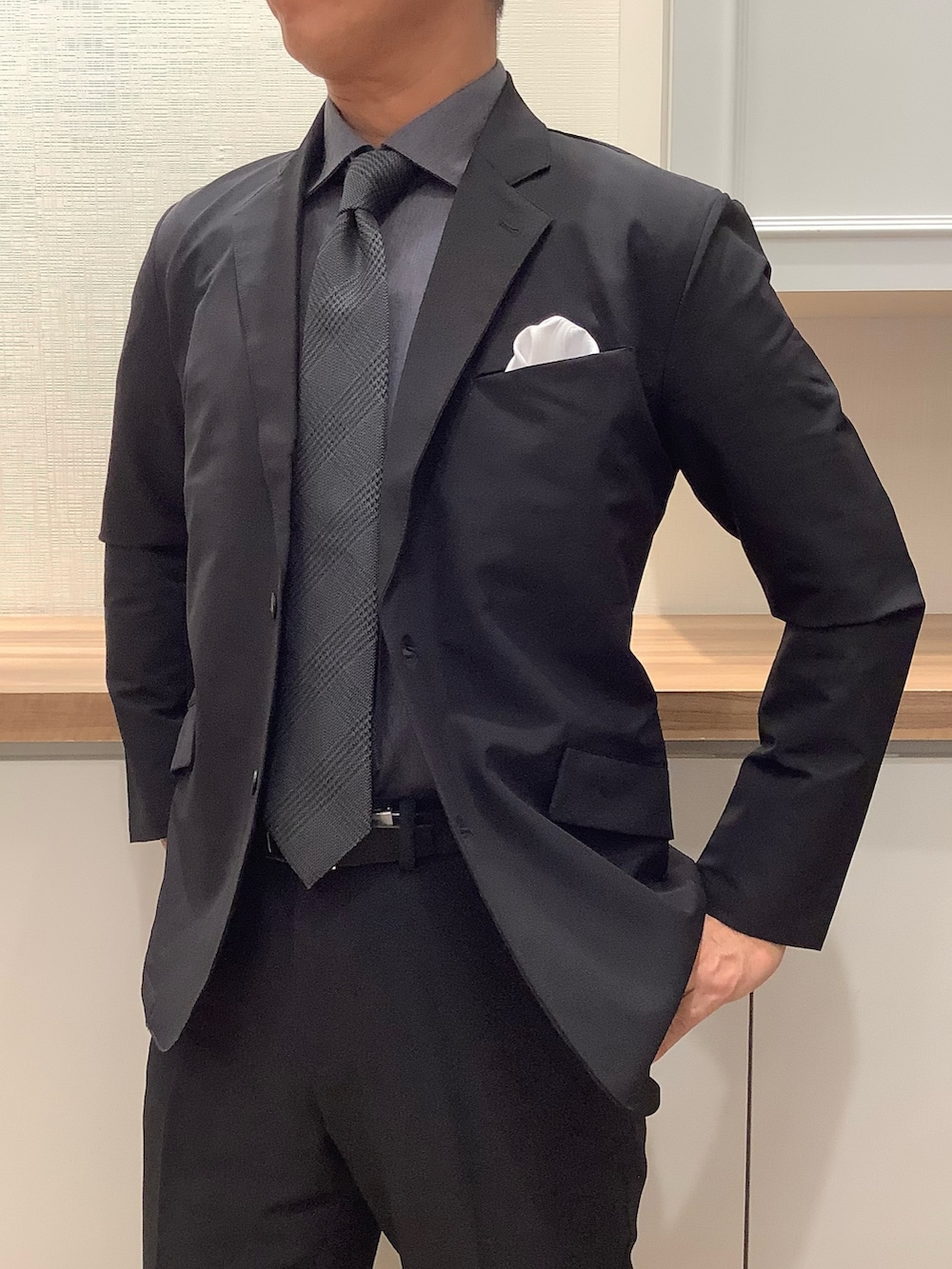 ブラック系のスーツジャケット、グレー系のネクタイ、グレー系のビジネスシャツを着用したメンズの秋コーディネートの2枚目の写真