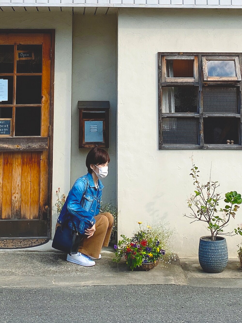 ホワイト系のスニーカー、ブルー系のデニムジャケット、ブラウン系のその他パンツを着用したレディースの夏コーディネートの3枚目の写真