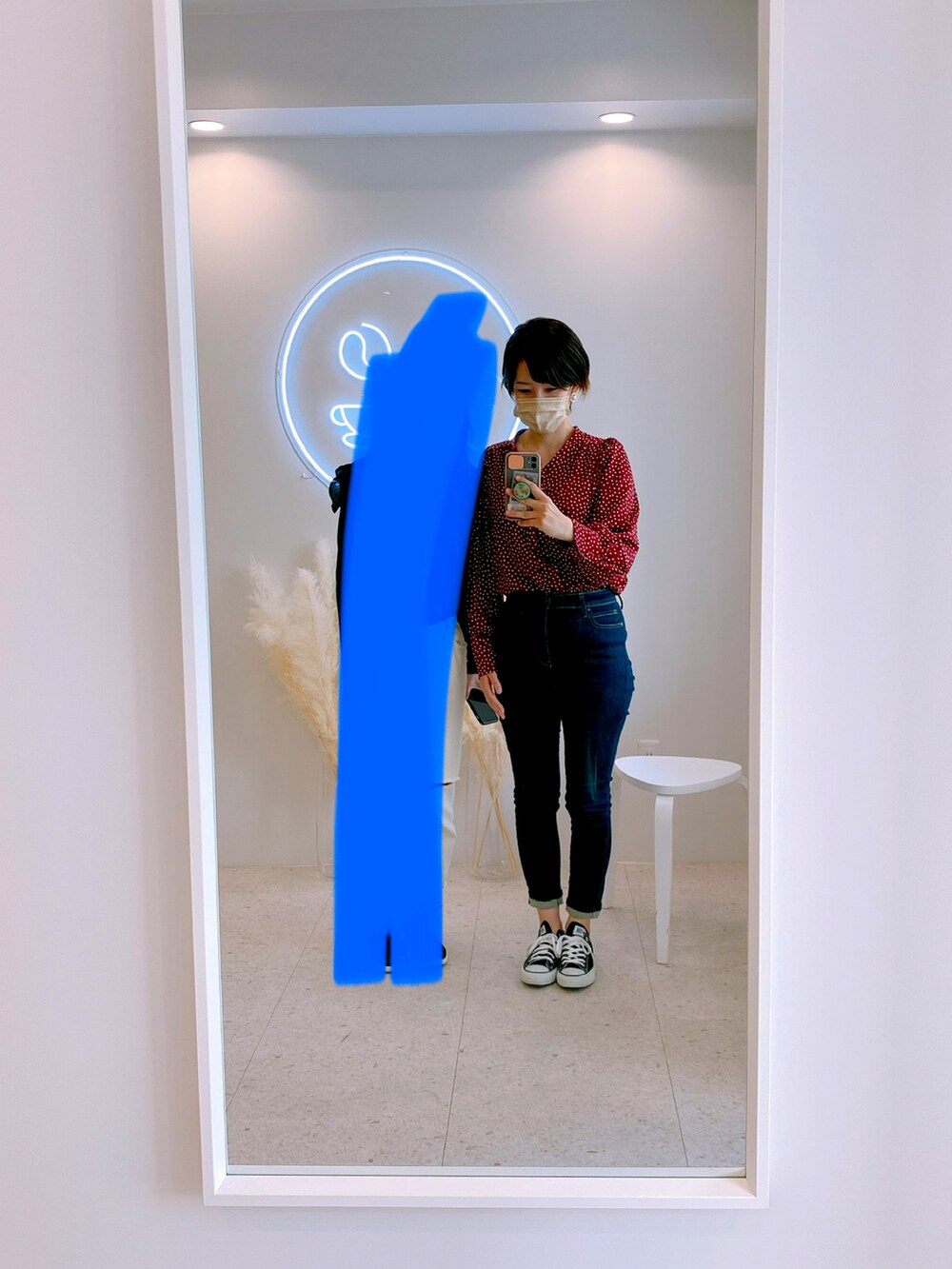 ブラック系のスニーカー、ブルー系のデニムパンツ、ホワイト系のその他アウターを着用したレディースの秋コーディネートの2枚目の写真