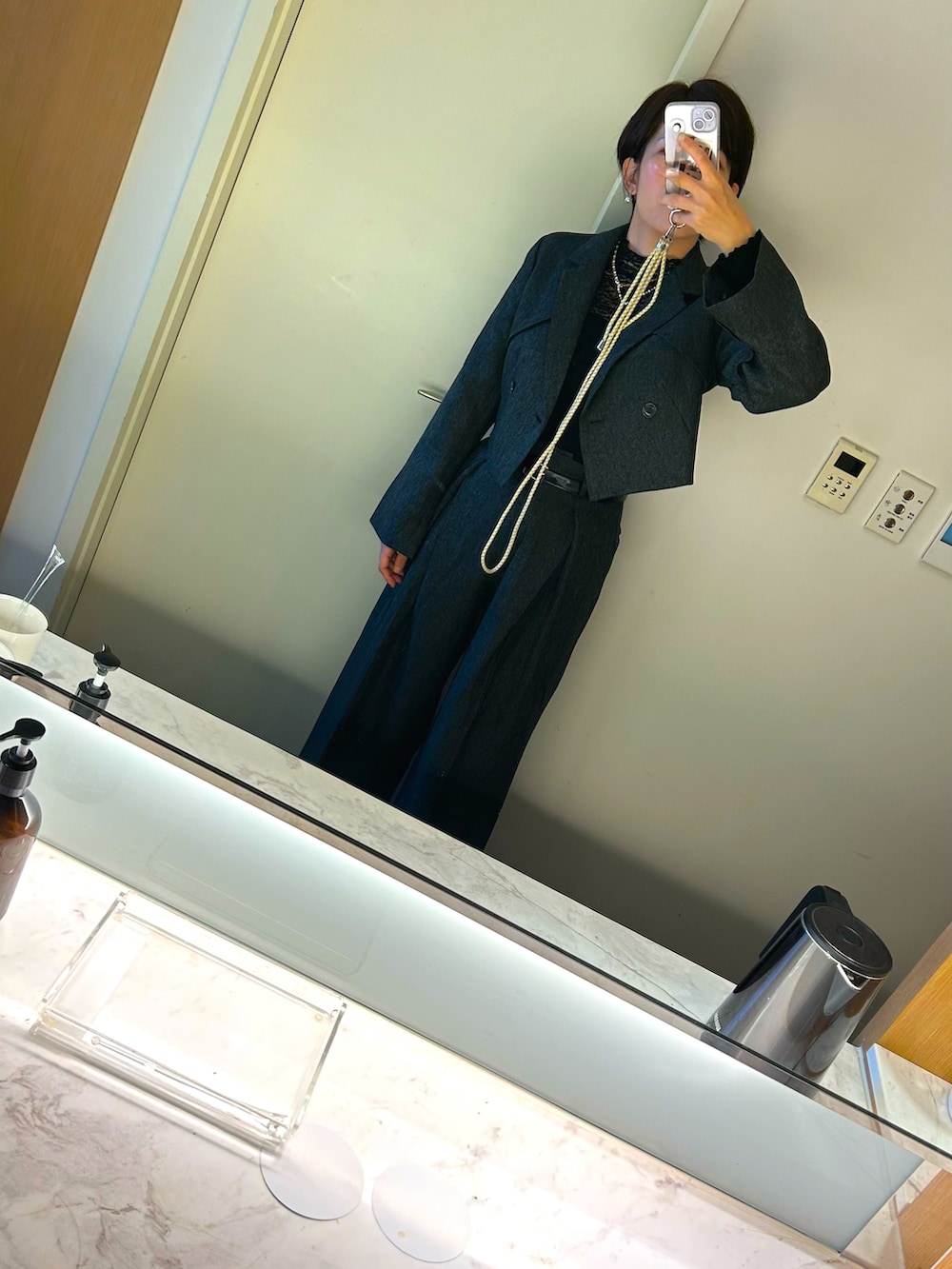 グレー系のスーツジャケットを着用したレディースの秋コーディネートの2枚目の写真