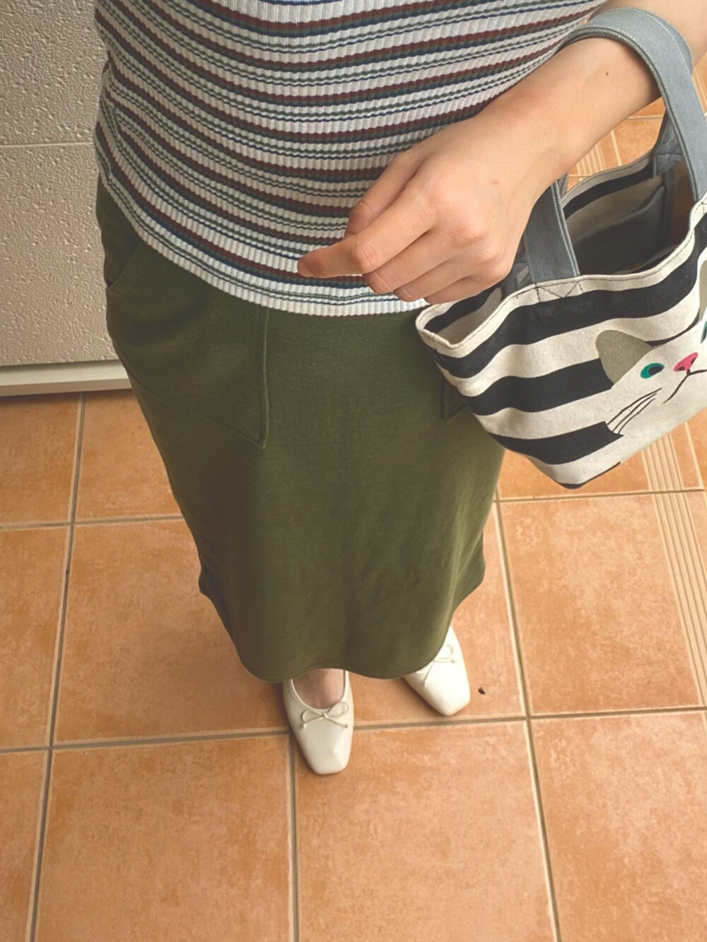 ベージュ系のパンプス、グリーン系のスカート、グリーン系のTシャツ/カットソーを着用したレディースの夏コーディネートの2枚目の写真