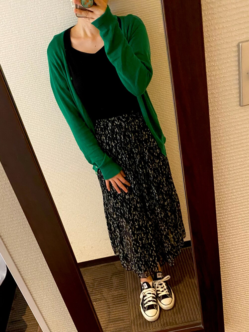 グリーン系のカーディガン/ボレロ、ブラック系のTシャツ/カットソー、ブラック系のスニーカーを着用したレディースの秋コーディネートの2枚目の写真