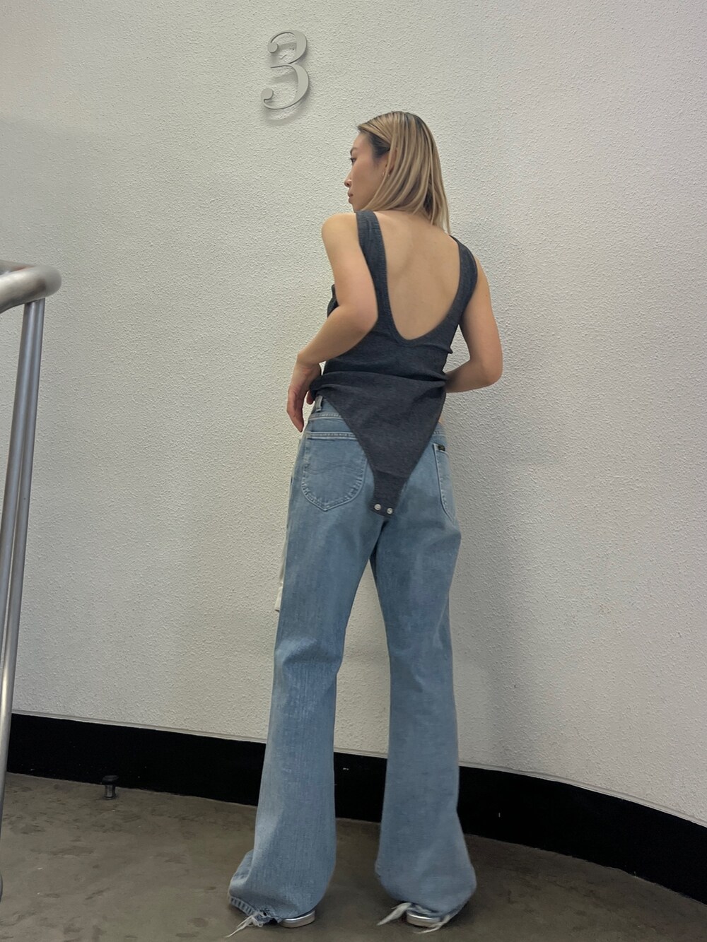 ブルー系のデニムパンツ、シルバー系のサンダル、グレー系のタンクトップを着用したレディースの冬コーディネートの3枚目の写真