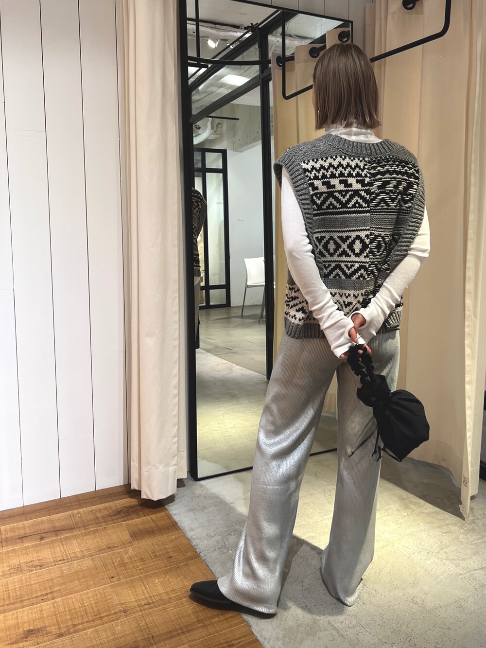 グレー系のニット/セーター、ホワイト系のTシャツ/カットソー、ブラック系のハンドバッグを着用したレディースの夏コーディネートの2枚目の写真