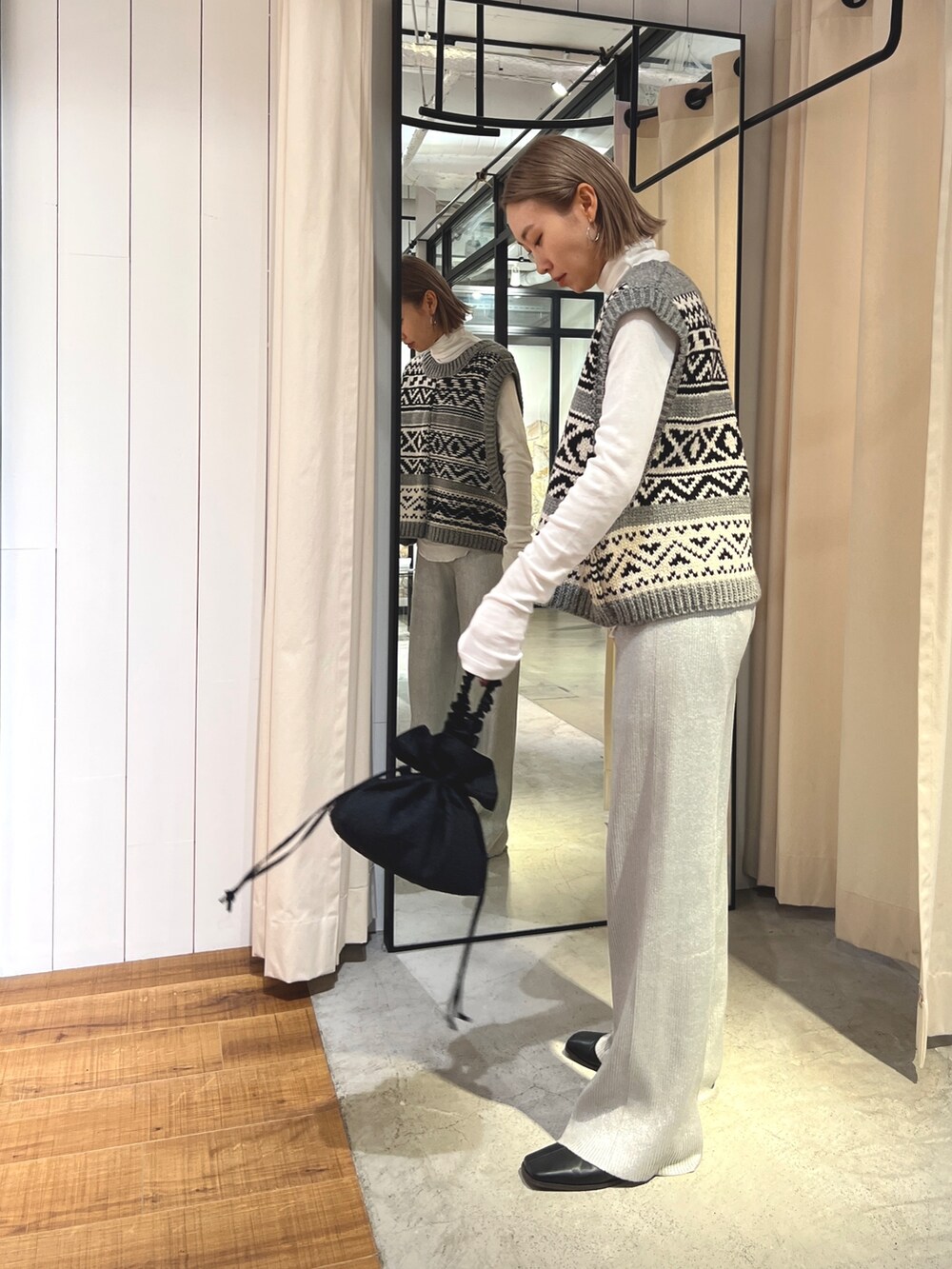 グレー系のニット/セーター、ホワイト系のTシャツ/カットソー、ブラック系のハンドバッグを着用したレディースの夏コーディネートの3枚目の写真